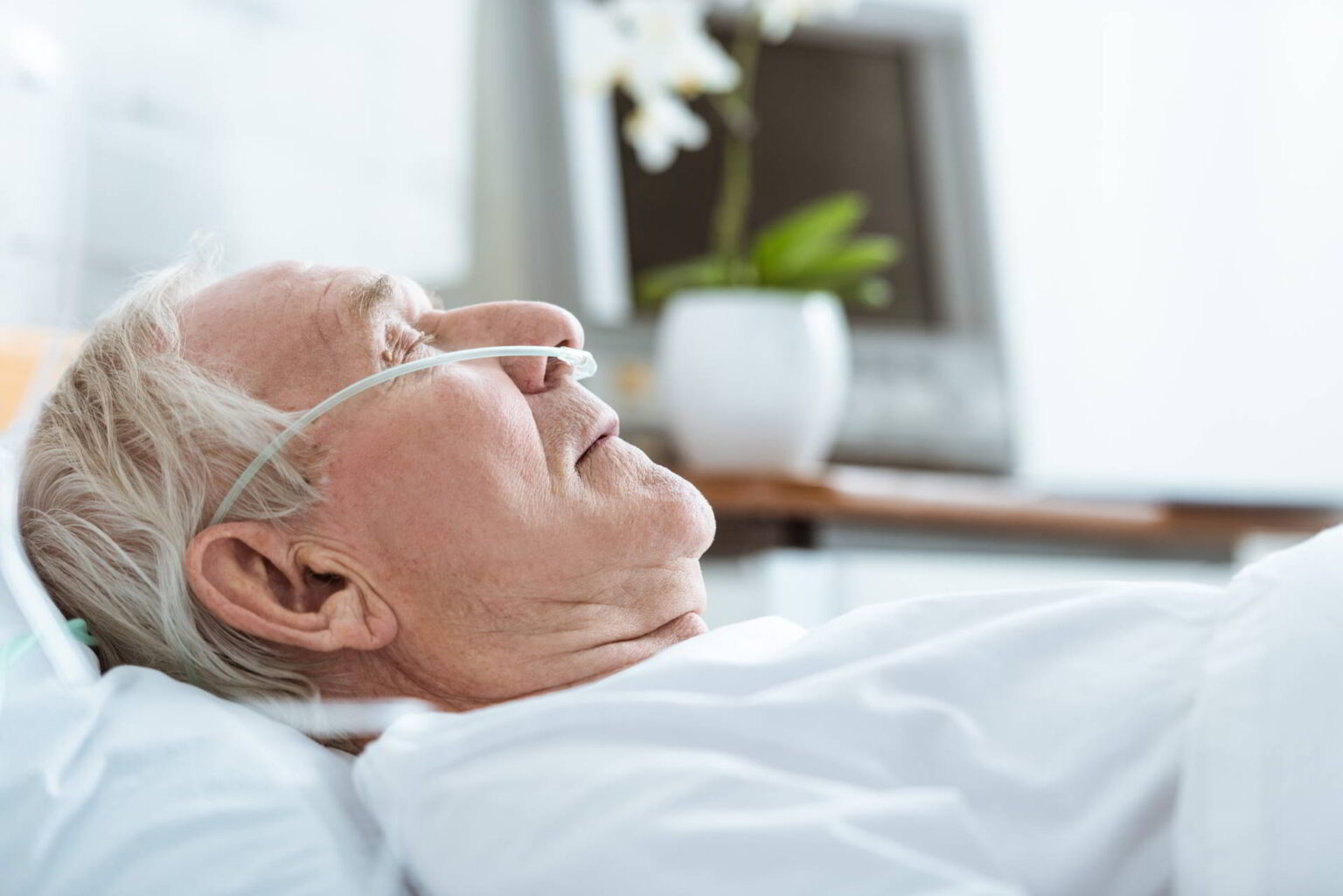 side view of senior man in bed with oxygen