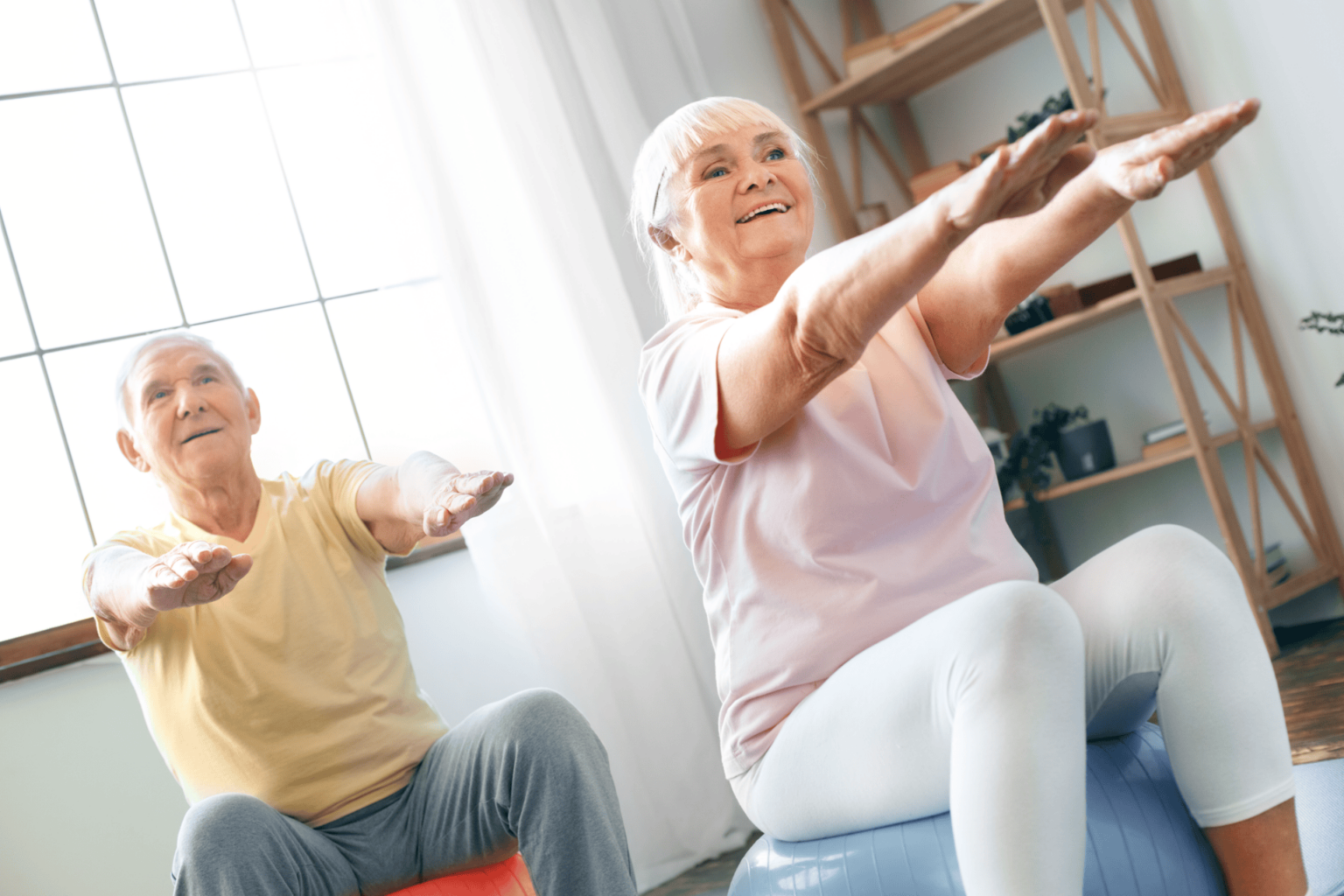 Two seniors sitting on large exercise balls trying to improve balance